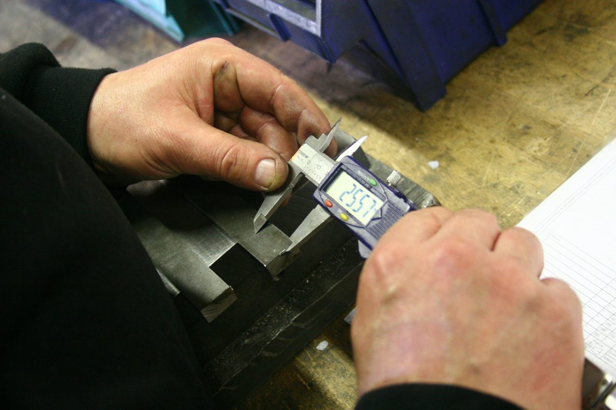 Technician verifying a part with a digital caliper